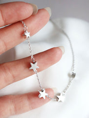 silver string of stars necklace in hand