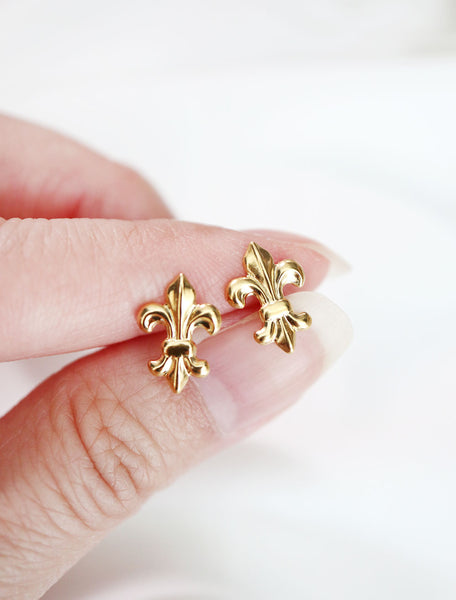 gold fleur de lis stud earrings in hand