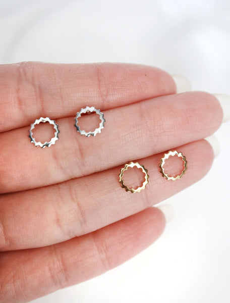 silver and gold scalloped circle studs in hand