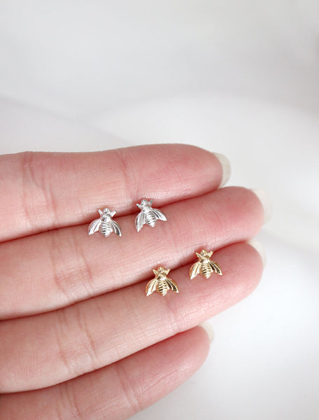 silver and gold bee stud earrings in hand