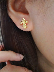 gold fleur de lis stud earrings modelled