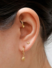gold seashell charm hoop earrings modelled