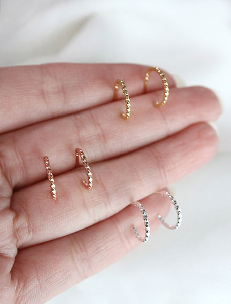 sterling silver twisted huggie hoop earrings in hand