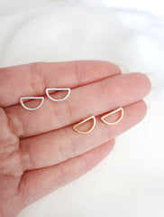 half circle stud earrings in hand