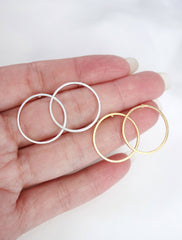 silver and gold circle hoop studs in hand