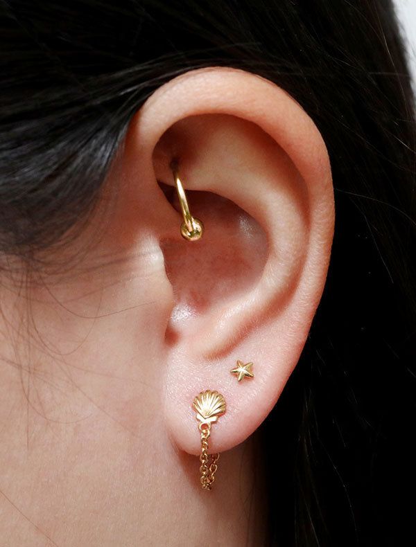 chained seashell stud earrings modelled in 14k gold fill