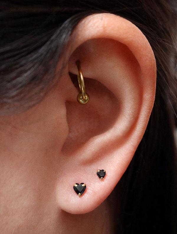 tiny black heart stud earrings modelled in gold vermeil