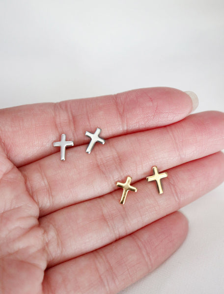 silver and gold tiny cross studs in hand