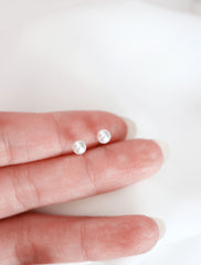 white pearl studs, genuine - held in hand