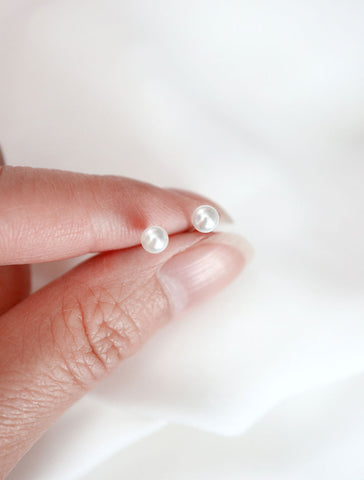 small pearl stud earrings in hand