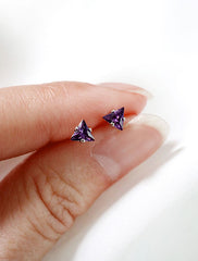 tiny amethyst triangle studs in hand, february birth stone