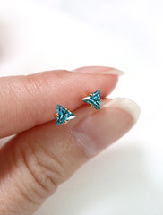 tiny blue topaz triangle stud earrings in hand, december birthstone