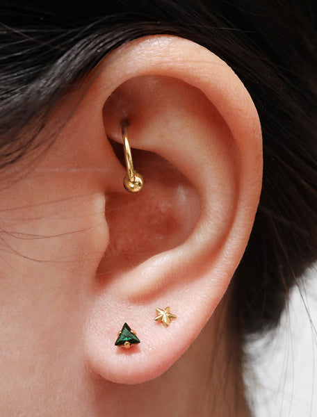 tiny emerald triangle stud earrings modelled, may birthstone