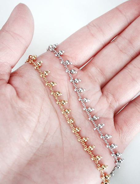 gold and silver beaded chain necklaces in hand