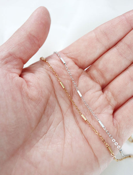 gold and silver dash chain in hand