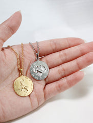 gold and silver large horoscope pendants in hand