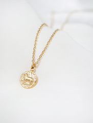 tiny gold horoscope necklace close up