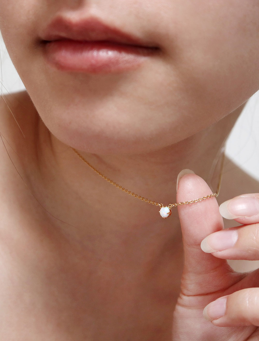 tiny opal necklace modelled up close