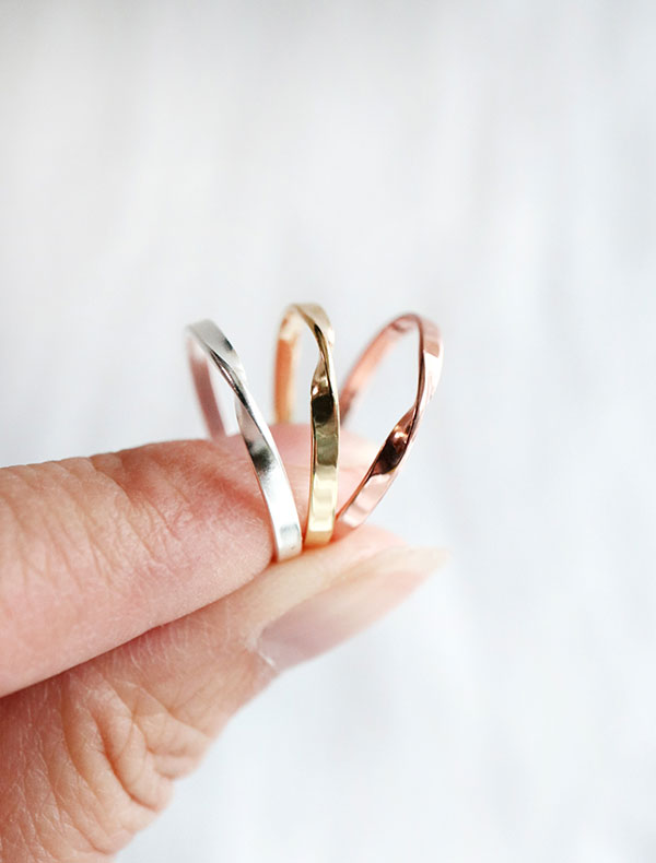 sterling silver flat twisted rings, in silver, 14k gold vermeil, and rose gold vermeil in hand